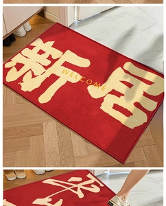 Détail du tapis de bienvenue en velours cristal rouge sur un sol en bois clair