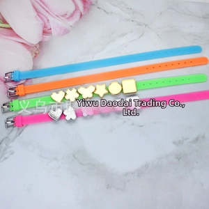 Colorful silicone bracelets with gold and silver metal charms on marble background