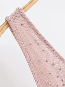 Detail of pink knit fabric with hand-stitched silver beads on a midi dress strap