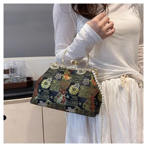 Detail of vintage embroidery bag with pearl chain and golden metal frame handle