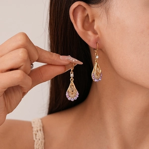 Vintage mesh teardrop earrings with purple zircon and gold finish on female model