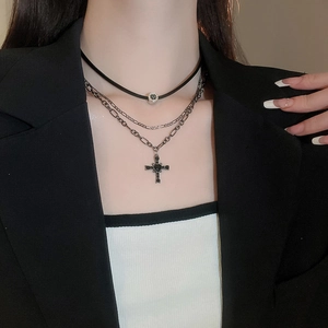 Dettaglio della collana gotica multistrato con croce e gemma nera su catena d'argento