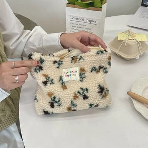 Detailed close-up of a plush faux sherpa makeup bag with flower patterns and zipper