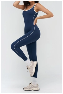 Close-up of deep blue yoga jumpsuit featuring white contrast trim and square neckline