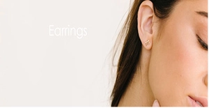 Close-up of three-bead gold stud earrings on model in a minimalist modern style