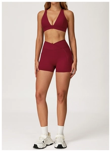 Detail of burgundy yoga set with V-shaped cross waistband and side pockets on shorts