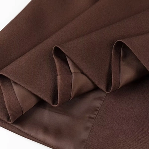 Détail du tissu en sergé marron foncé et des coutures professionnelles sur le blazer