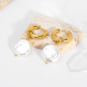 Baroque pearl hoop earrings in 18K gold plated stainless steel on a textured stone