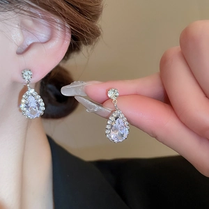 Detailed view of teardrop zircon earrings in silver finish worn for elegant styling