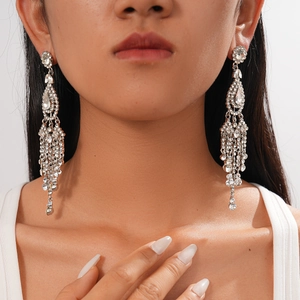 Detailed close-up of luxurious rhinestone flower tassel earrings on model