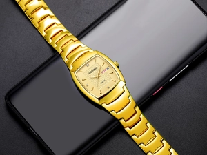 Macro-opname van gouden roestvrijstalen tonneau-horloge met dubbele kalender en champagne wijzerplaat