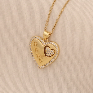 Close-up of golden heart pendant with MAMA engraving and sparkling small diamonds