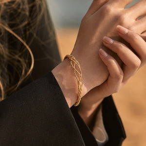 Minimalist gold woven bracelet with multi-strand layered design for women stylishly worn