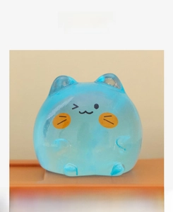 Detail of a translucent light blue cat figurine with cute facial expressions and orange cheeks