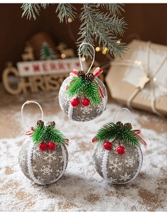Close-up of linen Christmas ball ornaments with pine needles and red berries on snow