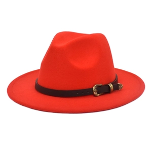 Detail of red fedora hat with black leather band and gold engraved buckle decoration