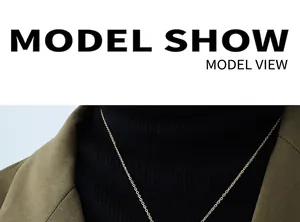 Golden fine chain necklace styled on a black turtleneck and olive green blazer