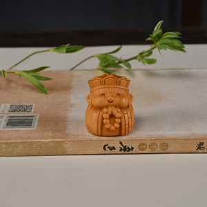 Statue de moine en bois de thuya sculpté à la main sur un livre ancien décoratif