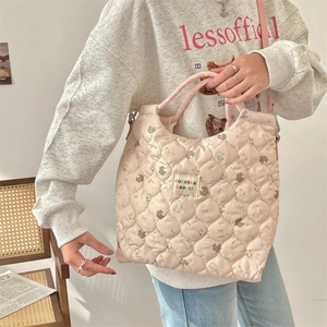 Detailed heart-quilted texture with cute bear and rabbit prints on a pink crossbody bag