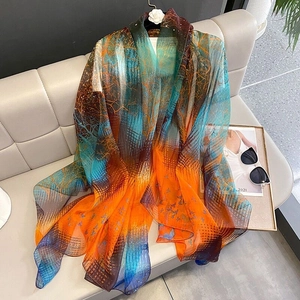 Detailed close-up of soft art print scarf featuring orange and blue gradient tree patterns