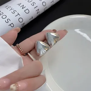 Minimalist silver geometric triangle stud earrings with a high-polished metallic finish