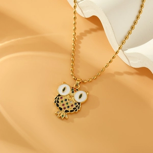 Exotic golden owl necklace with colorful zircons and seed beads on a white stone stand