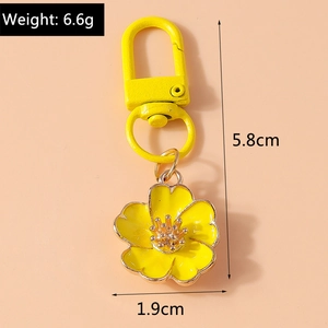 Detail view of yellow enamel flower keychain with dimensions 5.8cm and 6.6g weight