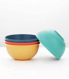 Macro detail of wheat straw soup bowls with vertical stripes in four vibrant colors