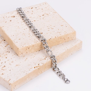 Classic 8mm silver stainless steel Figaro chain bracelet on elegant travertine stone