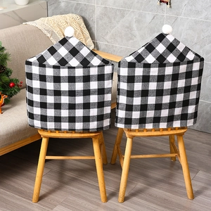 Christmas chair covers in black and white plaid design with white pom poms for holiday decor