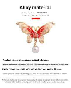 Detailed view of red and white butterfly brooch with rhinestones and hanging pearl