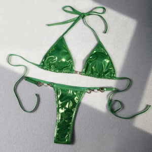 Detail of bright emerald green shiny bikini with white pearl accents and metal rings