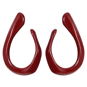 Macro view of dark red glossy resin bow earrings with polished finish and unique shape