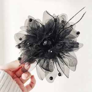 Detail of black flower hair claw clip with ostrich feathers, mesh fabric and polka dots