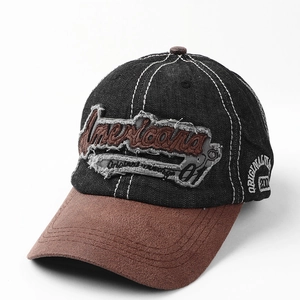 Detail of vintage baseball cap featuring denim fabric and brown suede brim with embroidery