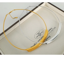 Detail of minimalist gold and silver snake chain necklaces with curved tubes