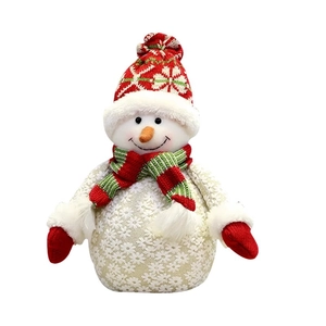 Pupazzo di neve in peluche natalizio con cappello a maglia rosso e sciarpa a righe