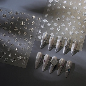 Silver and white snowflake nail art stickers with star motifs and metallic gloss finish