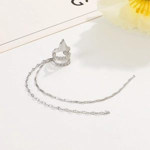 Detail of silver double-layered ear cuff with long metallic chain tassels on white background