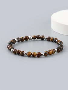 6mm natural tiger eye stone beaded bracelet with metal accents on minimalist grey surface