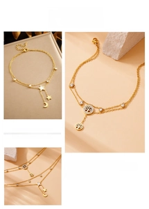 Detail of double-layered gold anklet with star, moon, and tree of life pendants