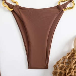 Detail of brown ribbed bikini bottom with a wavy gold metal chain ornament on white background