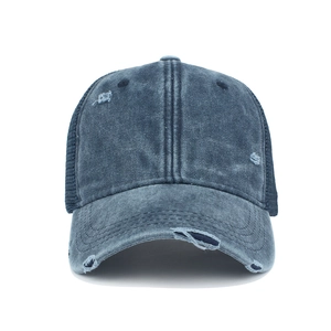 Detail of distressed navy denim baseball cap with vintage holes and mesh back