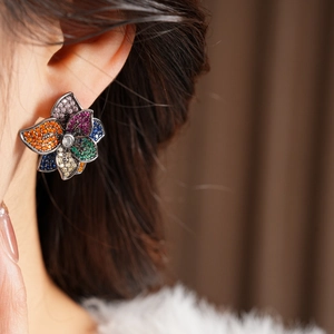 Detail of vintage silver needle flower earrings with colorful zircon stones on model
