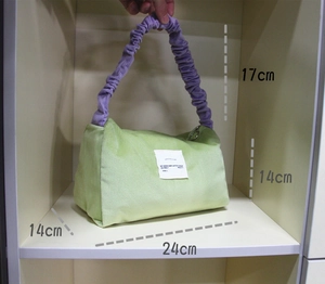 Detail of corduroy handbag with light green fabric and purple pleated handle showing dimensions