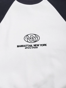 Detail of embroidered NY Manhattan text on a raglan sleeve color-block sweatshirt