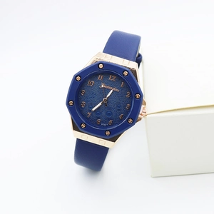 Détail de la lunette octogonale en or rose avec cadran floral et bracelet en cuir bleu foncé
