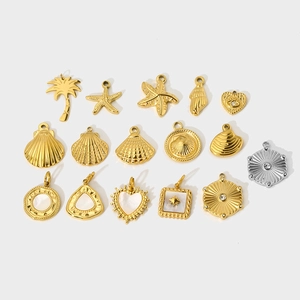 Flat lay of 14K gold and silver tropical ocean charms featuring starfish and shells