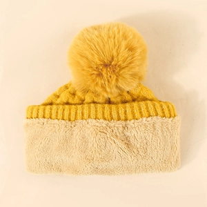 Detail of winter ginger knit beanie showing large fur pom-pom and thick plush lining