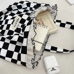 Detail of checkered canvas tote bag with lace trim showing interior storage capacity